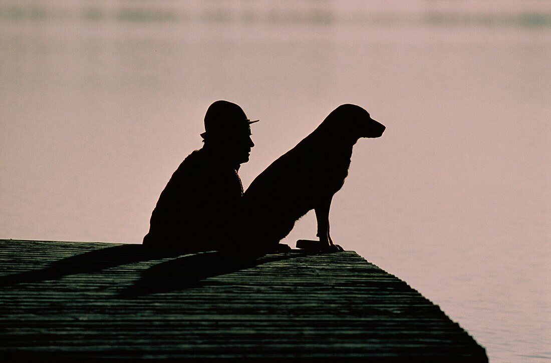 Mann mit Hund am Steg