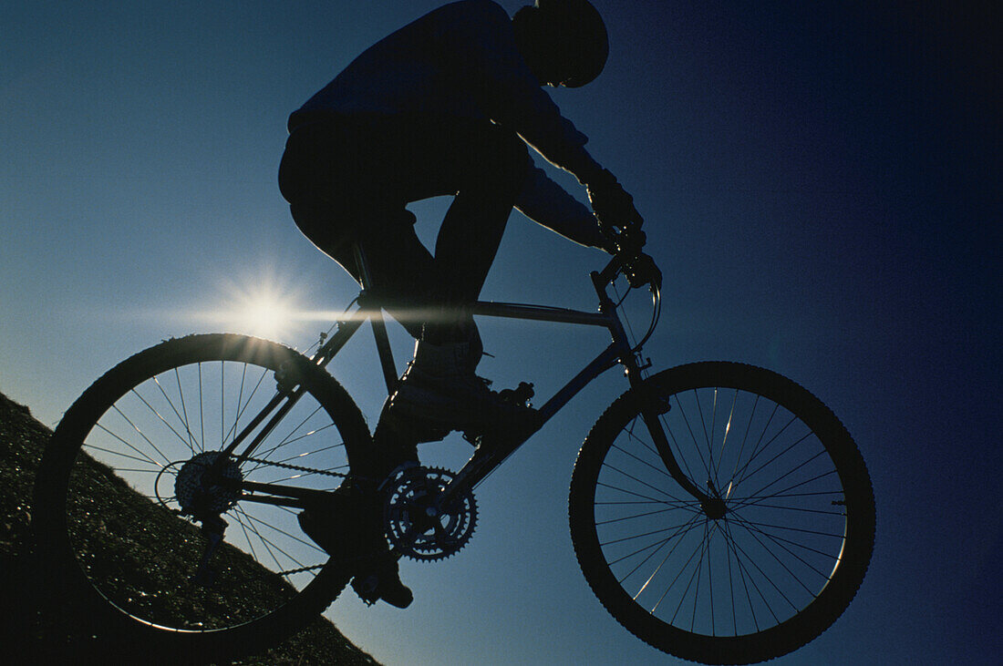 Biker jumping in backlight