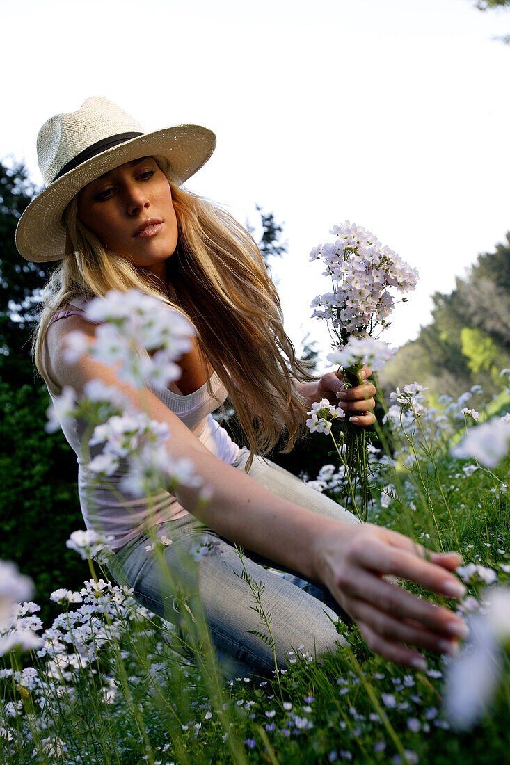 Young woman picking flowers, Icking, Bavaria, Germany