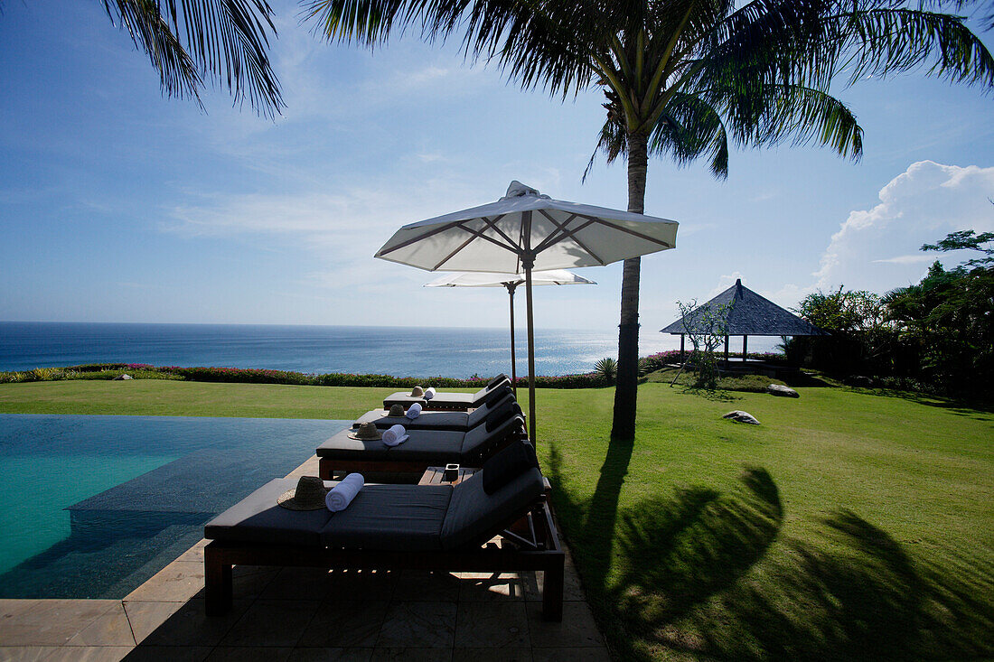 Liegestuhle am Rand des Pools, nahe Uluwatu, Bali, Indonesien