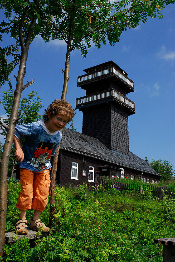 Ein Kind, Junge, springt von Bank, am Leipziger Turm, Schmiedefeld, Thüringen, Deutschland