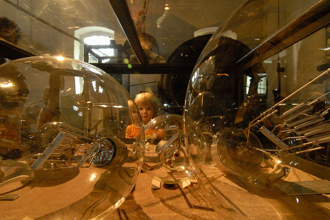 Child watching giant bulbs, hydro power museum, Ziegenruck, Thuringia, Germany
