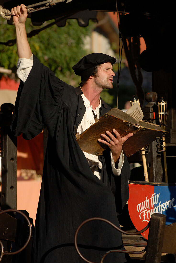 Ein Schauspieler, als Martin Luther verkleidet, deklamiert auf dem Karussel auf dem Mittelaltermarkt, Luther das Fest, Eisenach, Thüringen, Deutschland