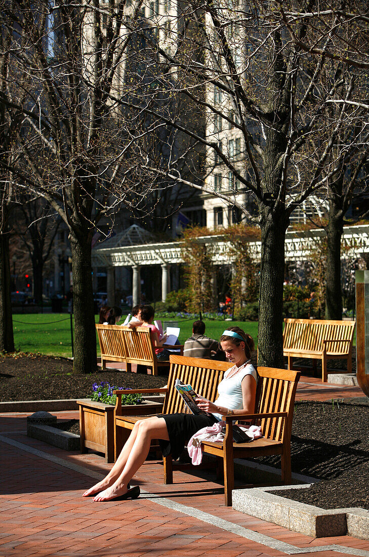 Frau sitzt im Park und liest, Post Office Plaza, Boston, Massachusetts, USA