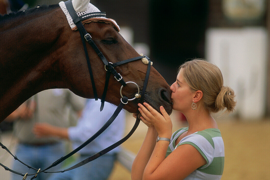 Young woman kissing horse, Ising, Chieming, Chiemgau, Upper Bavaria, Germany