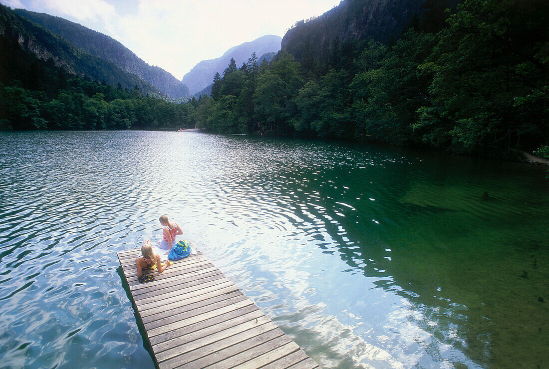 Zwei jungen Frauen sitzen auf Badestege am Thumsee, Bad Reichenhall, Berchtesgadener Land, Oberbayern, Bayern, Deutschland