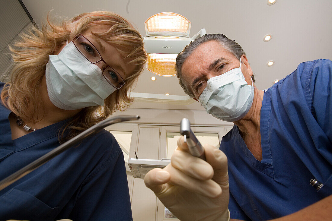 Zahnbehandlung, Zahnbehandlung beim Zahnarzt, Zahnarzt und Helferin beugen sich über den Patienten. Praxis Dr. Vesic, Hannover