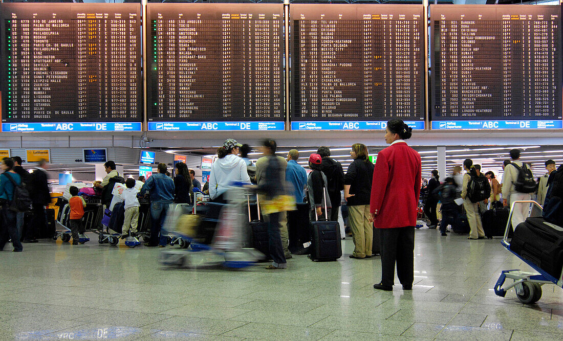 Travellers waiting at the flight information board, Frankfurt Airport, Hesse, Germany