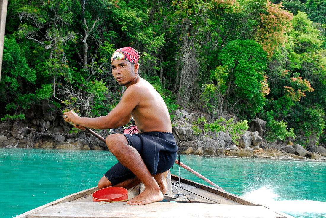 Local man steering a longtail boat, Surin Islands Marine National Park, Ko Surin, Phang Nga, Thailand