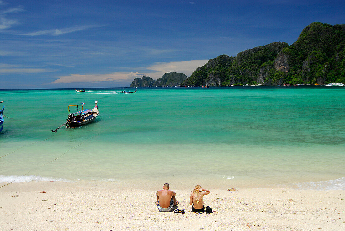 Couple sitting on the beach, Ao Ton Sai, Ko Phi Phi, Krabi, Thailand