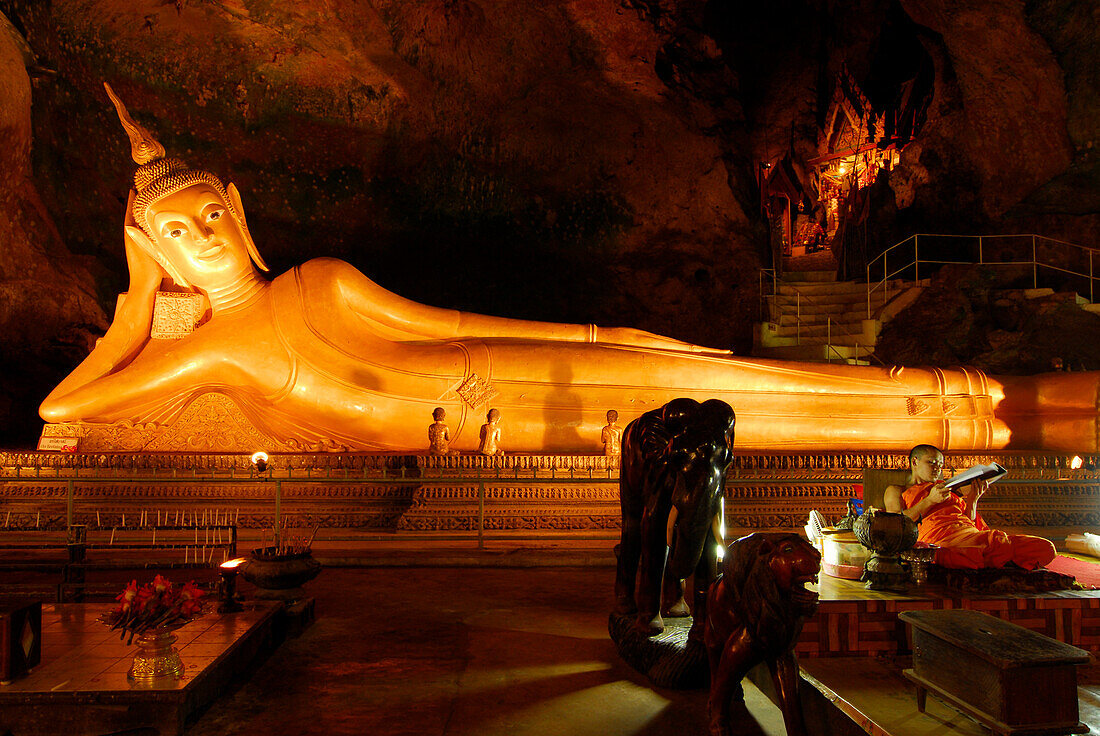 Liegender Buddha und buddhistischer Mönch in der Tham Yai  Höhle beim Kloster Wat Suwan Kuha, Phang Nga, Thailand