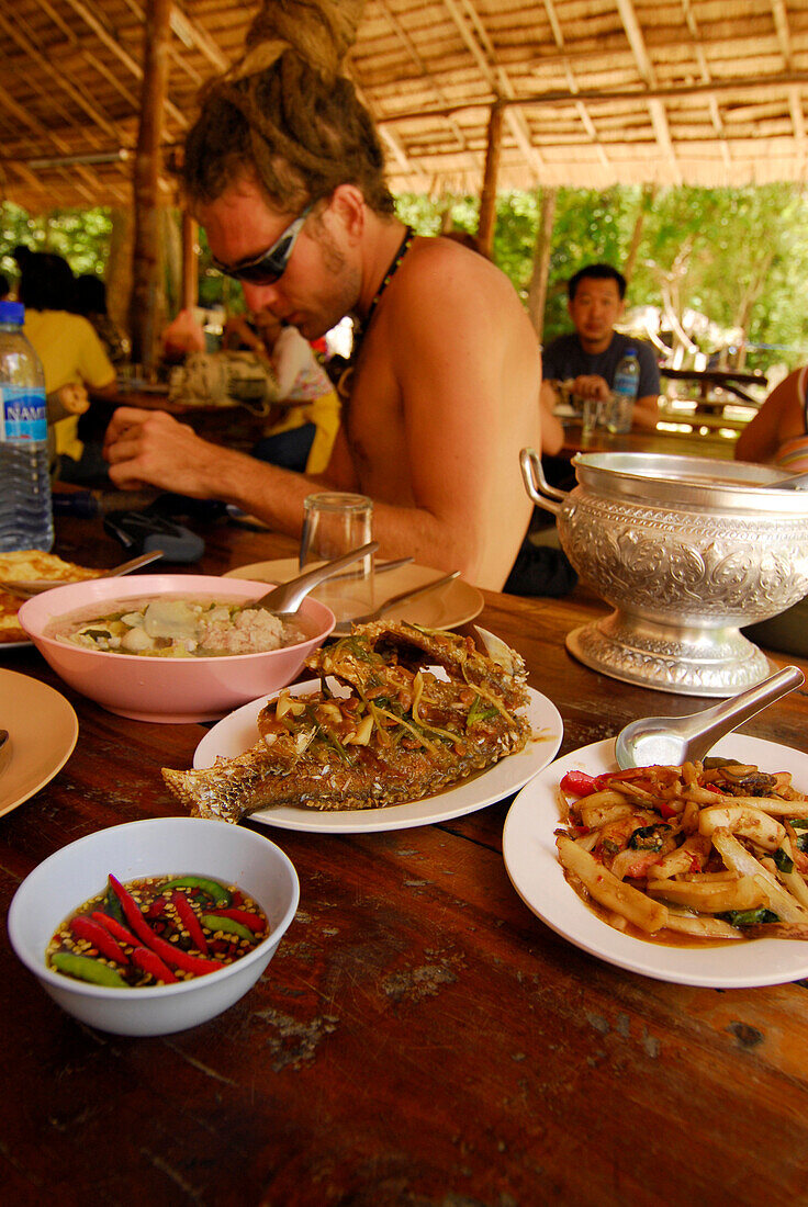 Young man eating Thai food, set menu, Surin Islands Marine National Park, Ko Surin, Thailand