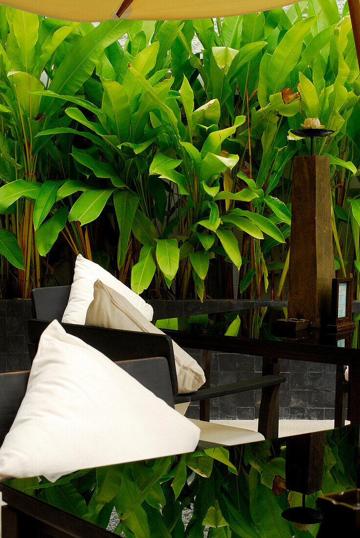 Tables with table decorations and plants at the poolbar of Hotel Manatai, Had Surin, Phuket, Thailand