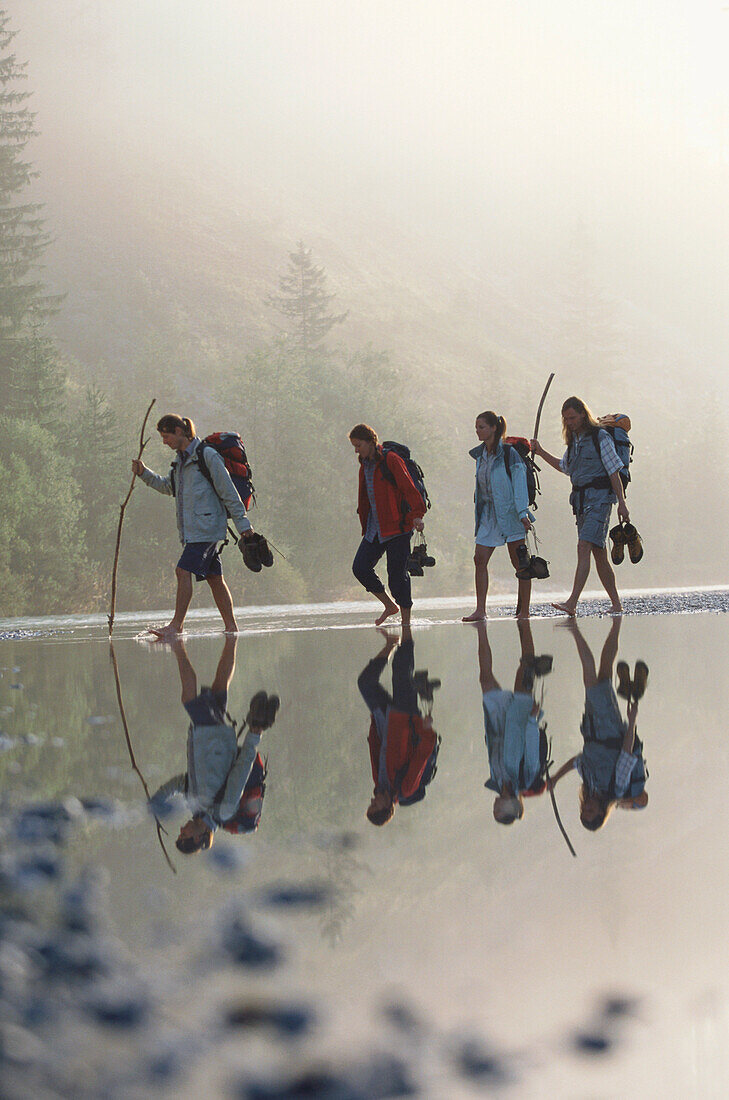 Gruppe Wanderer durchquert Sylvenstein See, Bayern, Deutschland