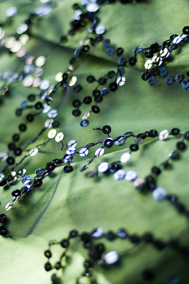 Close up of green material with a pattern of sequins