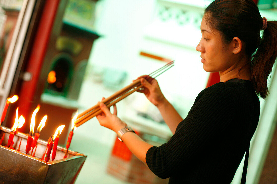 Frau mit Räucherstäbchen und Kerzen, Tempel, Singapur