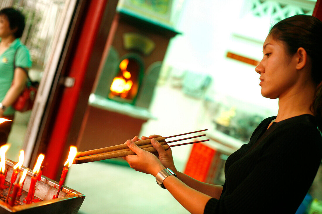 Frau mit Räucherstäbchen und Kerzen, Tempel, Singapur