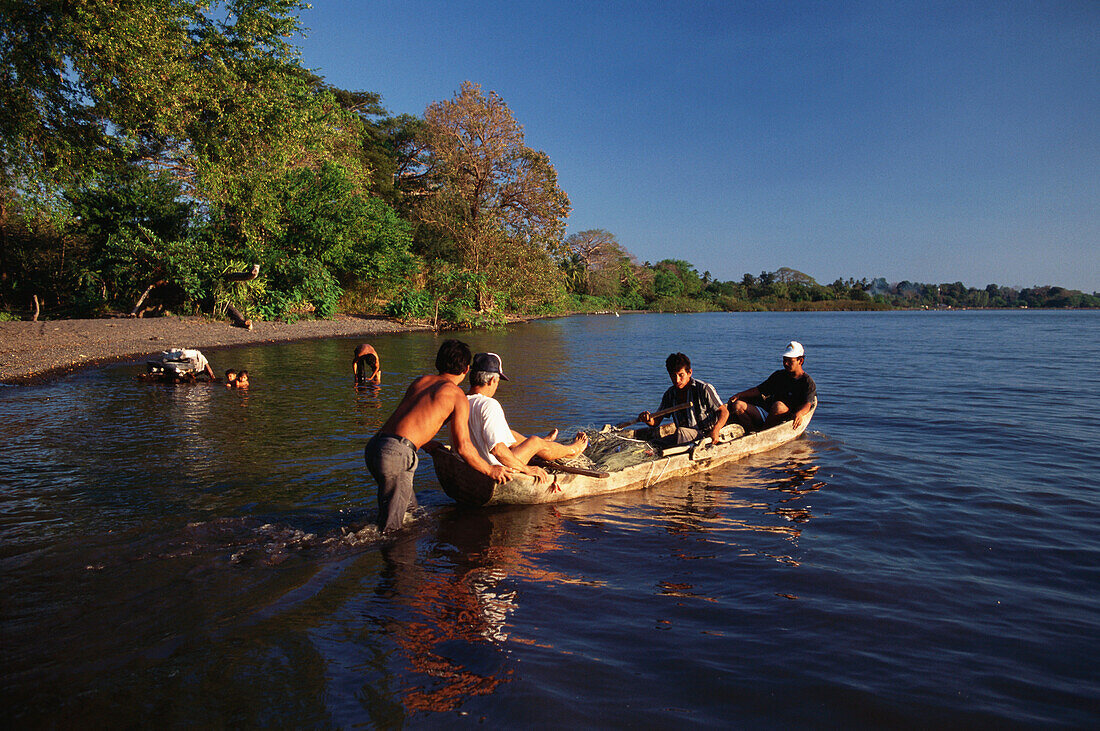 Fishermen sitting in a log boat, Moyagalpa, Isla de Ometepe, Lake Nicaragua, Nicaragua, Central America