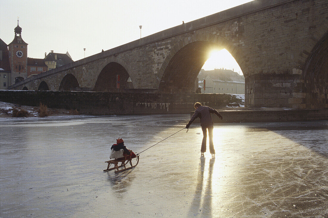 Mother and child on frozen river Danube, Stony Bridge, Regensburg, Upper Palatinate, Bavaria, Germany