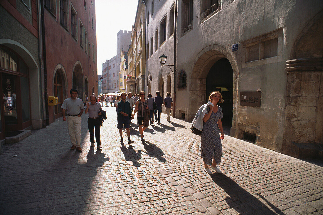 Menschen spazieren auf gepflasterter Gasse in der Altstadt, Regensburg, Oberpfalz, Bayern, Deutschland