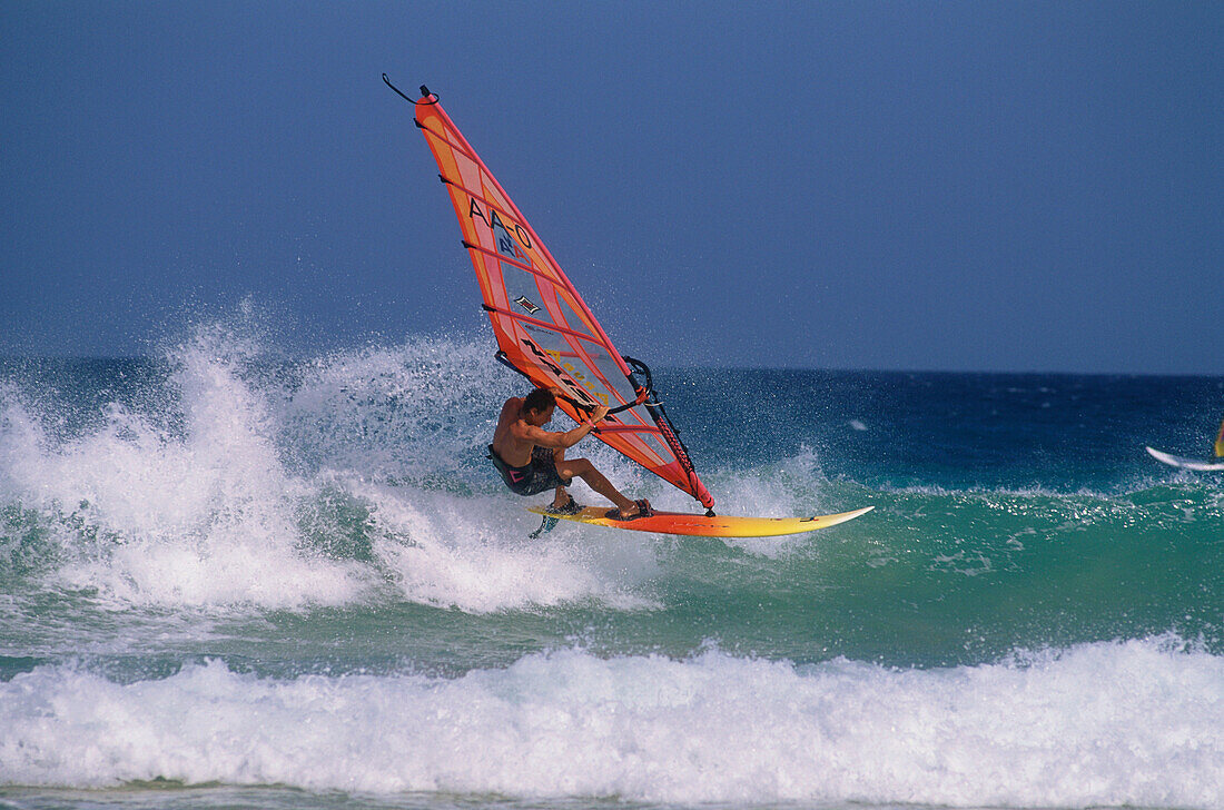 Ein Windsurfer reitet auf den Wellen der Brandung, Jandía Halbinsel, Fuerteventura, Islas Canarias, Kanarische Inseln, Spanien
