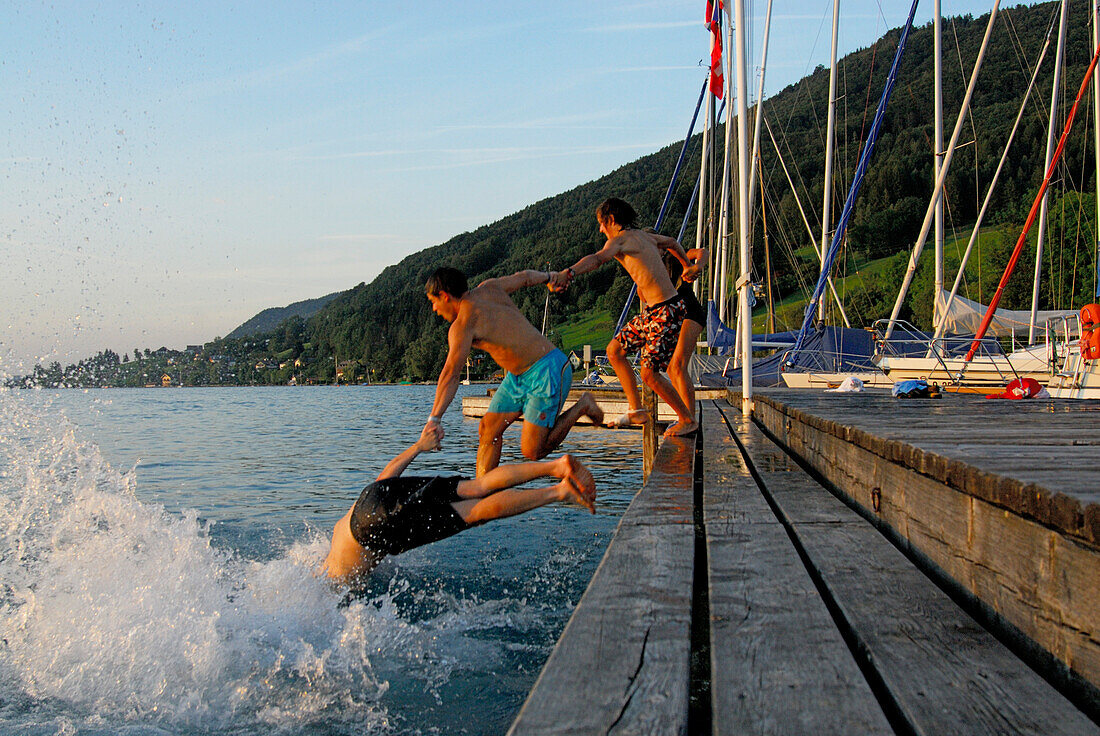 young men diving from landing stage, lake Attersee, Salzkammergut, Salzburg, Austria