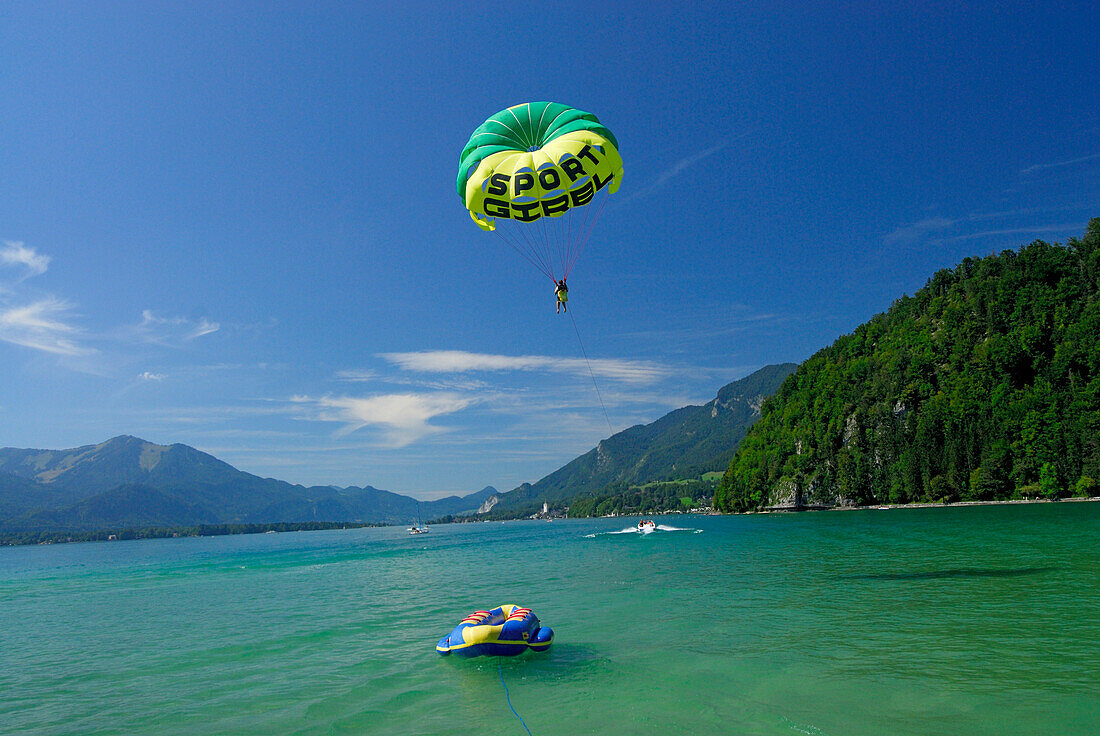 junge Frau beim Parasailing hinter dem Motorboot, Abersee, Wolfgangsee, Salzkammergut, Salzburg, Österreich