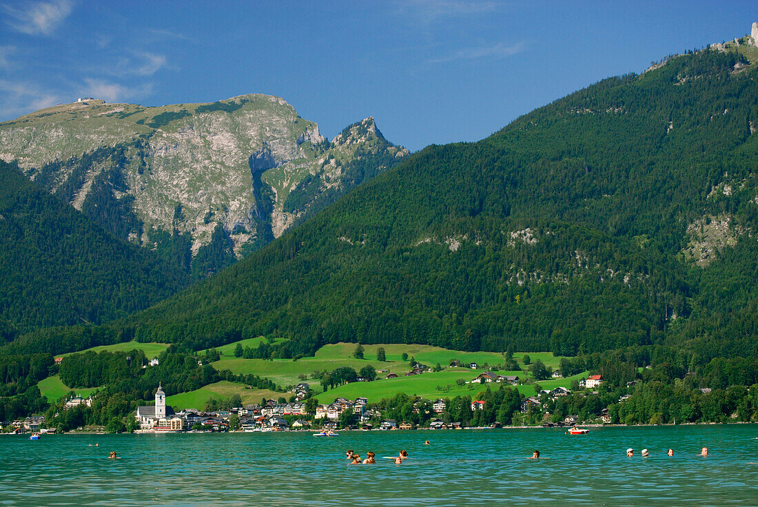 People bathing in lake Wolfgangsee, view to St. Wolfgang and mount Schafberg, Salzkammergut, Salzburg, Austria