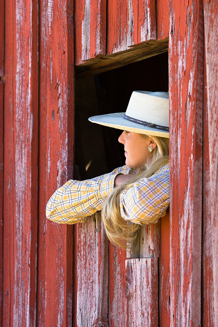 cowgirl looking out of barn-window, wildwest, Oregon, USA