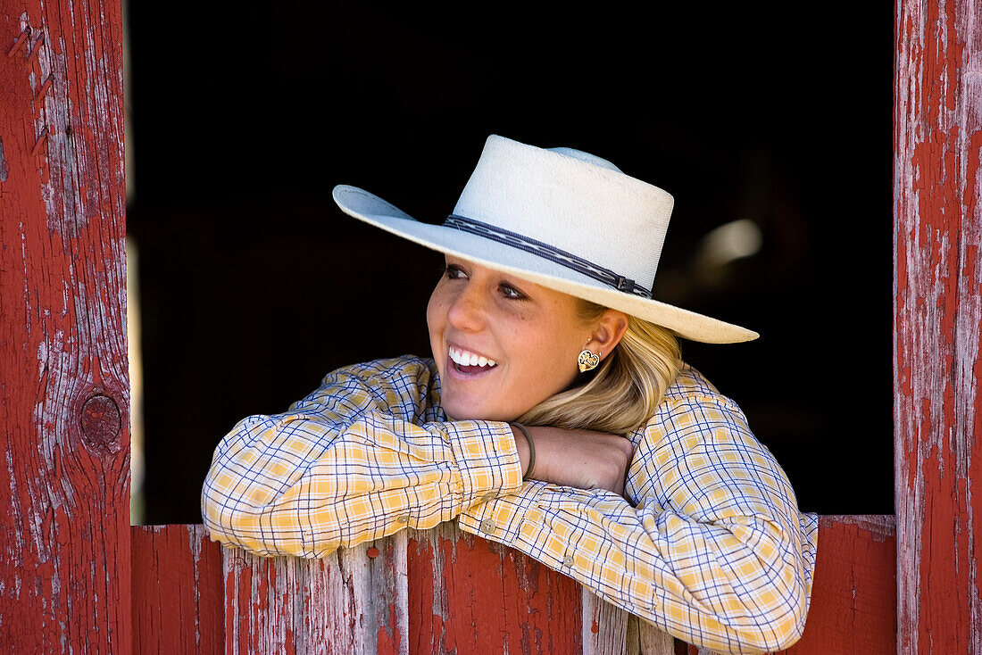 Cowgirl looking out of barn-window, wildwest, Oregon, USA