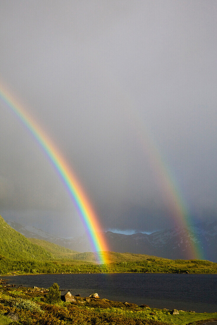 Doppelter Regenbogen, Regenschauer und Sonnenstrahlen bei Sandsletta, Insel Austvagoya, Lofoten, Norwegen