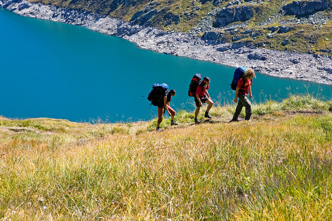 Drei junge Leute bei einer Bergwanderung, Stausee Lago di Lucendro, Gotthard, Kanton Tessin, Schweiz