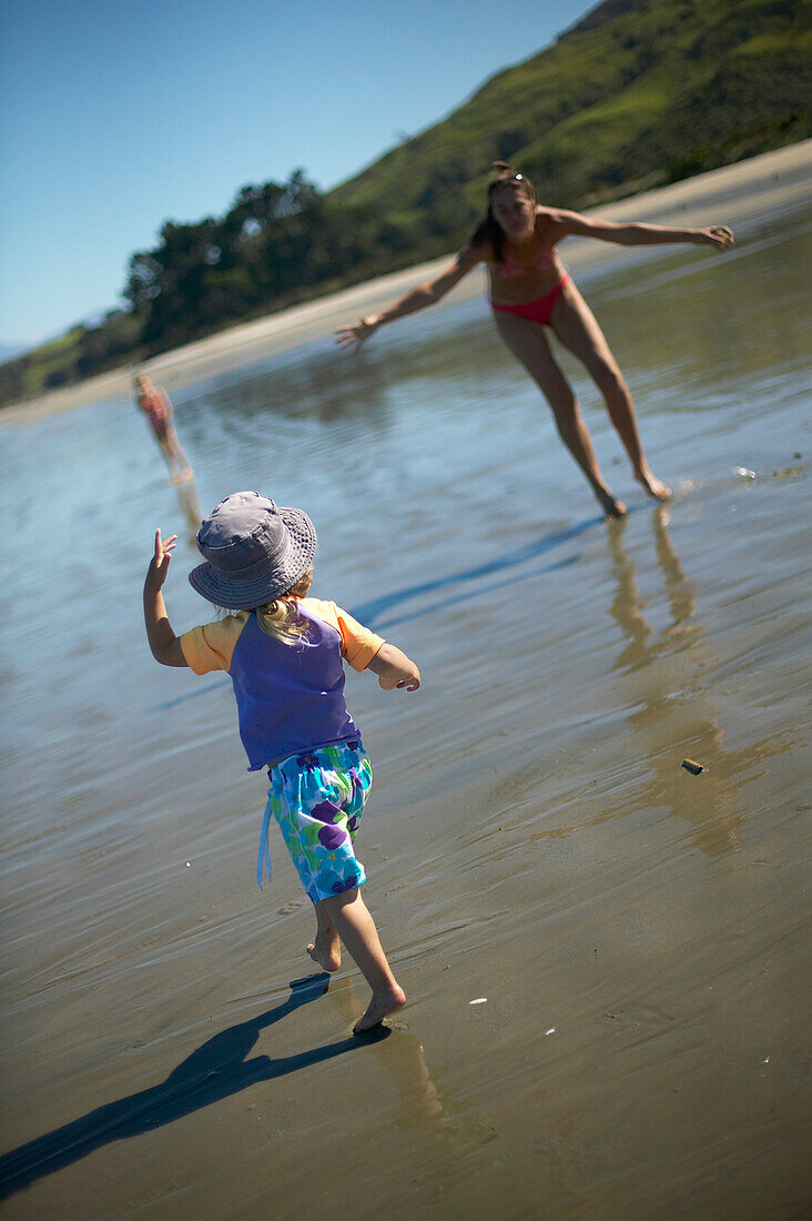Mother and daughter playing at Pakawau beach, Golden Bay, northern coast of South Island, New Zealand