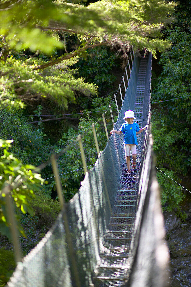 Mädchen auf Hängebrücke über Fluß, Wanderung im Abel Tasman Nat.Park, Nordüste, Südinsel, Neuseeland