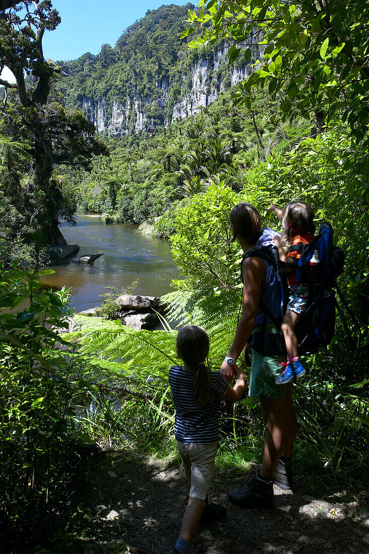 Mother with children at riverside, hiking in Punakaiki National Park, north of Hokitika, Westcoast, South Island, New Zealand