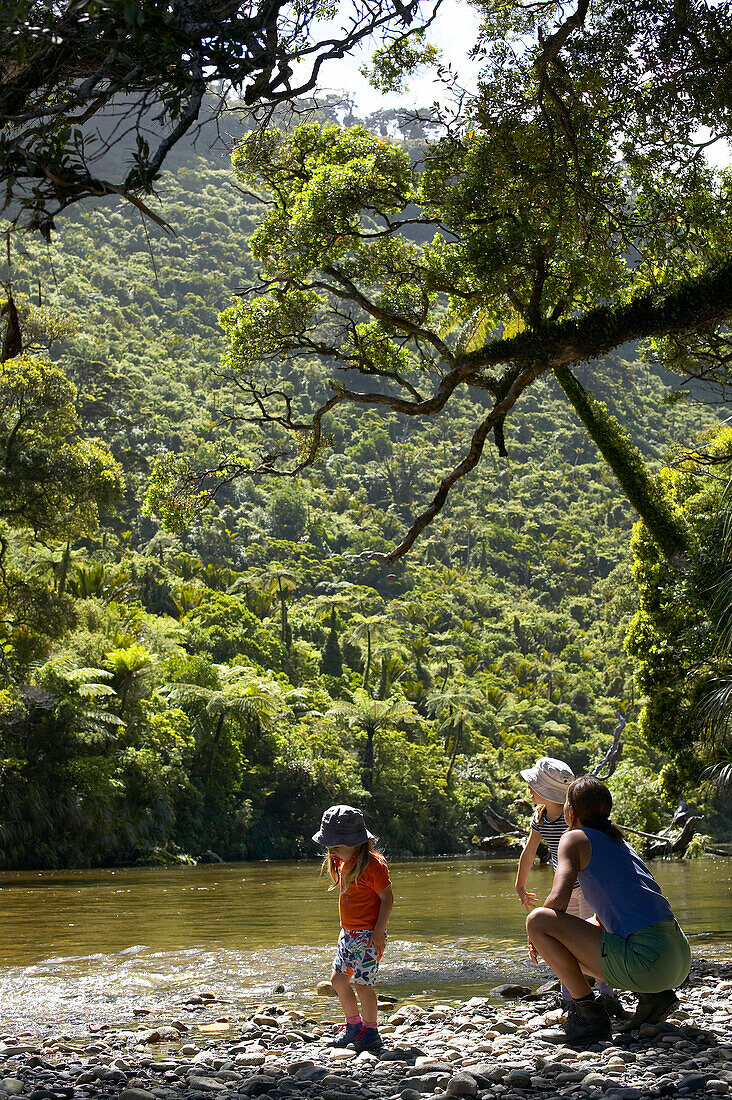 Mother with children at riverside, hiking in Punakaiki National Park, north of Hokitika, Westcoast, South Island, New Zealand