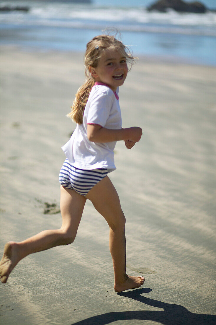 Kind läuft am Strand der Little Okains Bay, flaches Wasser, Bank's Peninsula, Ostküste, Südinsel, Neuseeland