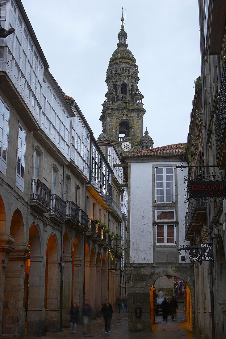 An alley in the old part of the town in the evening with clock tower in the background, Torre del Reloj, Santiago de Compostela, Galicia, Spain