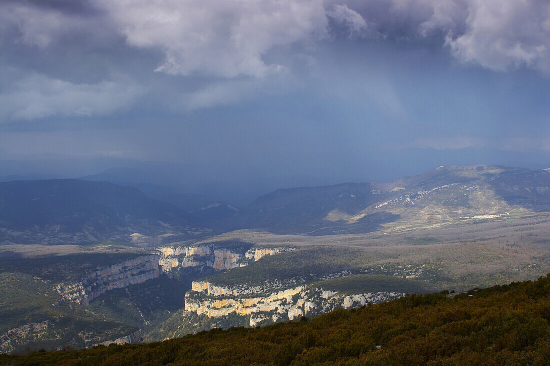 Dramatic sky and landscape from mount Arangoiti towards canyon Foz de Arbayun and river Río Salazar, Navarra, Spain