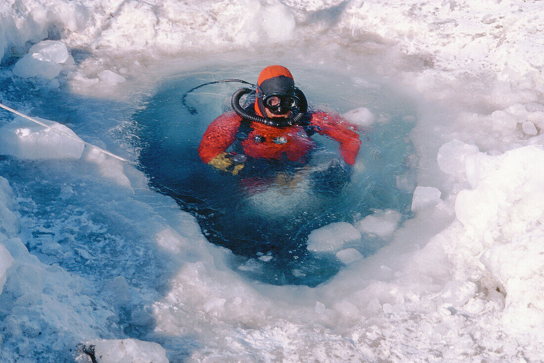 Adult, Adults, Cold, Coldness, Color, Colour, Contemporary, Daytime, Diver, Divers, Diving mask, Diving masks, Exploration, Exterior, Frozen, Hole, Holes, Horizontal, Human, Ice, Looking at camera, Nature, Neoprene suit, Neoprene suits, One, One person, 