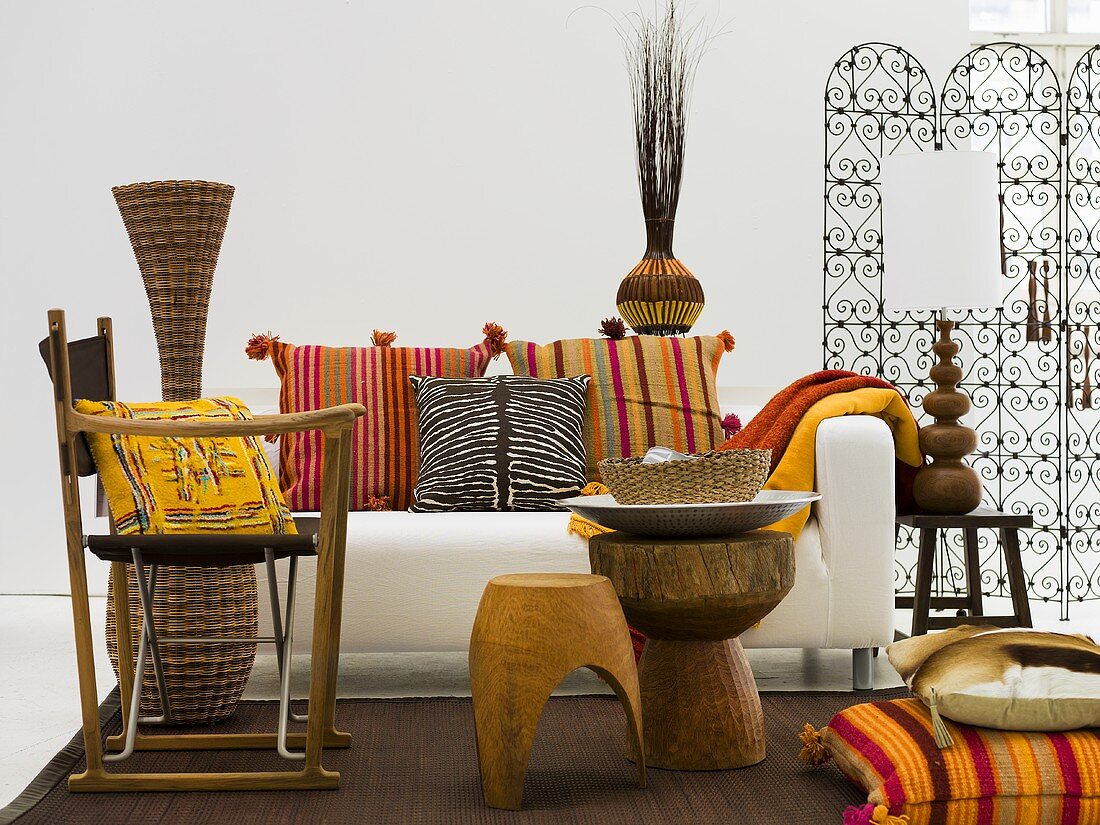 Rustic chair and stool in front of a white sofa with colorful pillows