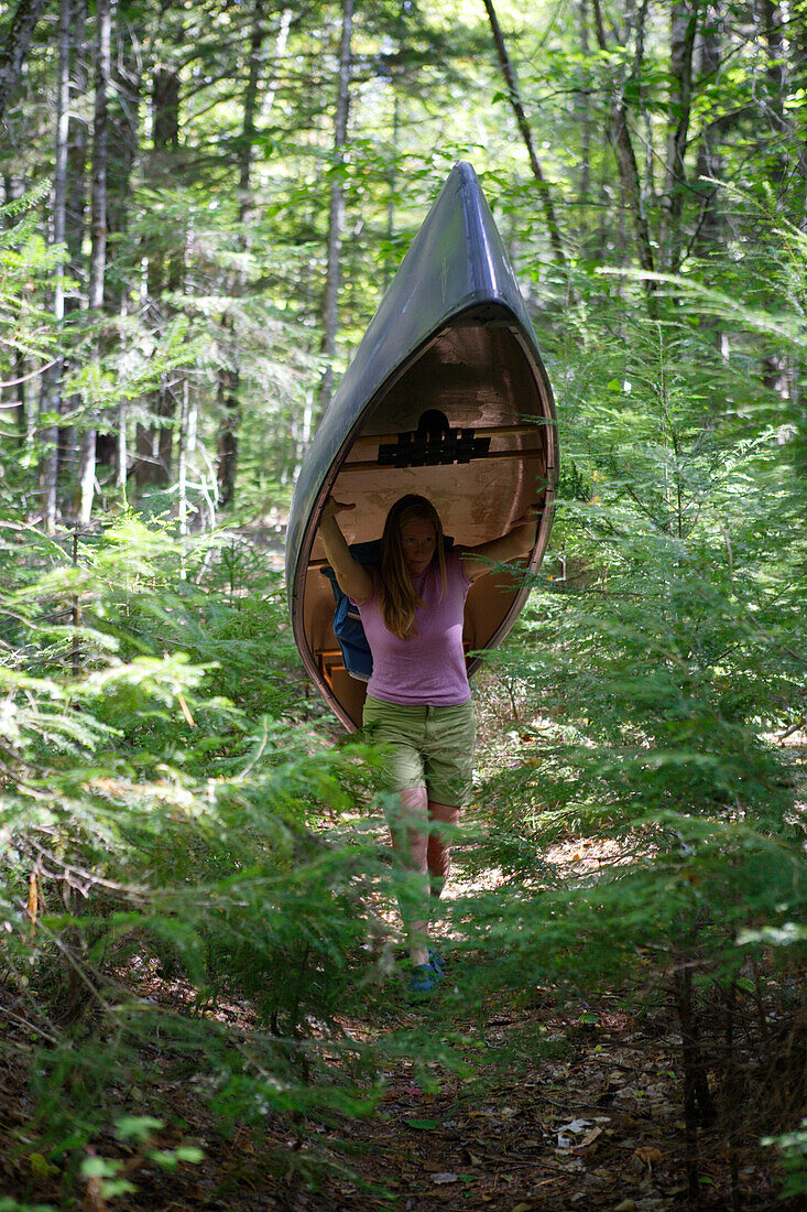 Girl carries a boat on Penobscot River, Maine, ,USA