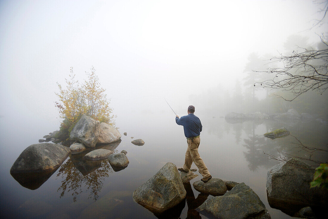 Man flyfishing in the morning light on Lake Millinocket, Maine, United States of America, USA