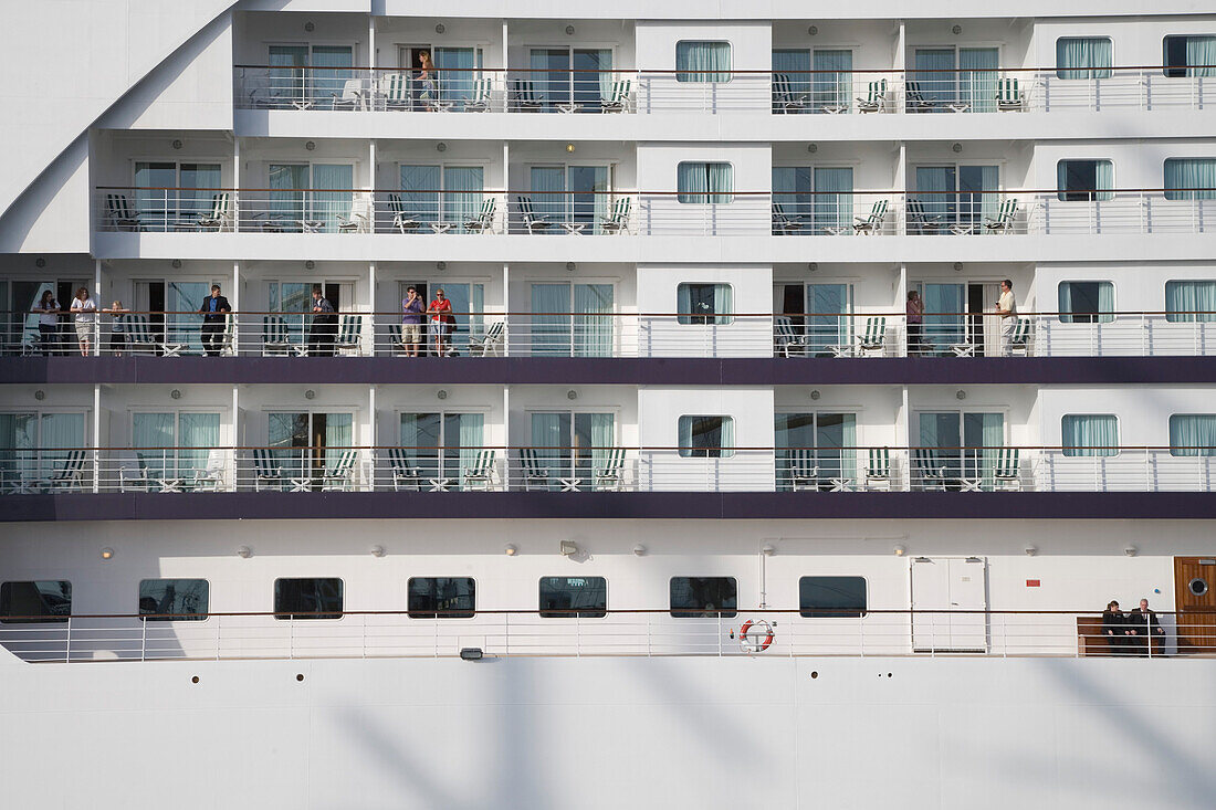 Passagiere auf Balkonen vom Kreuzfahrtschiff Seven Seas Voyager im Hafen von Civitavecchia, nahe Rom, Lazio, Italien, Europa