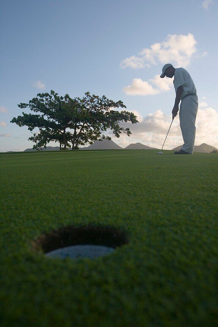 Golfer am Grün des 11. Loch Round the Bend am Le Touessrok Golfplatz, Insel Ile aux Cerfs, nahe Trou d'Eau Douce, Flacq District, Mauritius, Indischer Ozean