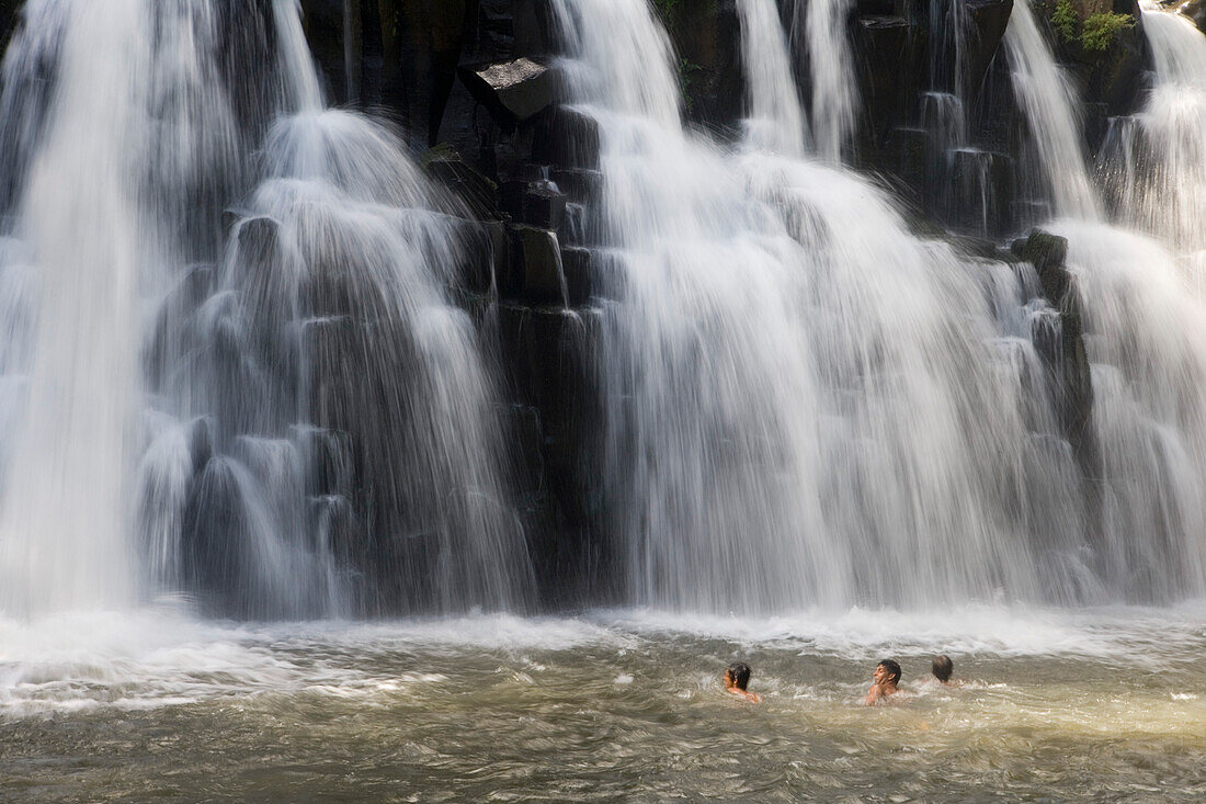 Männer schwimmen im Wasserbecken unter dem Rochester Falls Wasserfall, nahe Surinam, Savanne District, Mauritius, Indischer Ozean