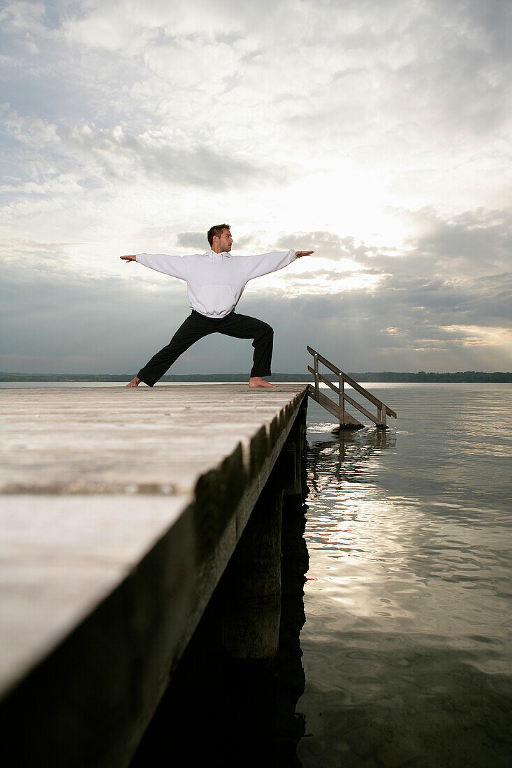 Mann beim Yoga am Starnberger See, Münsing, Bayern, Deutschland, MR