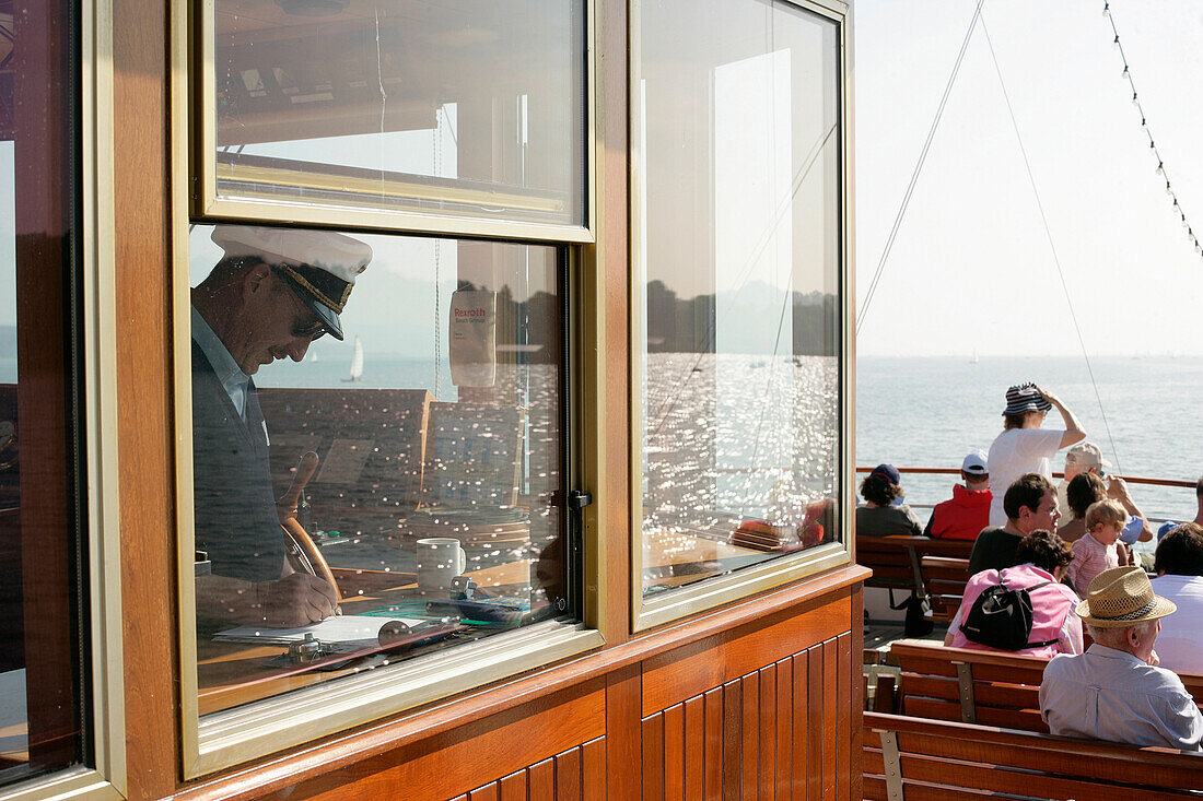 Captain and passengers on ferry crossing Lake Starnberg, Starnberger See, Bavaria, Germany