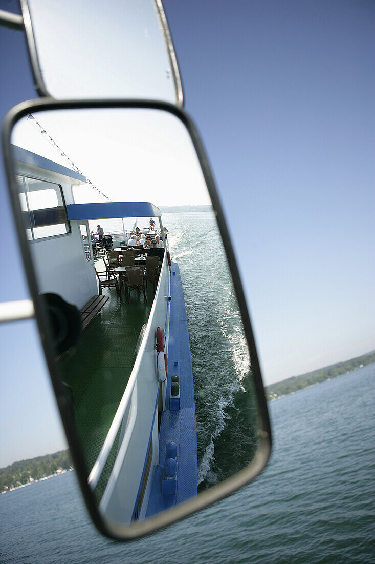 Blick in einen Rückspiegel von einem Ausflugsboot auf dem Starnberger See, Bayern, Deutschland