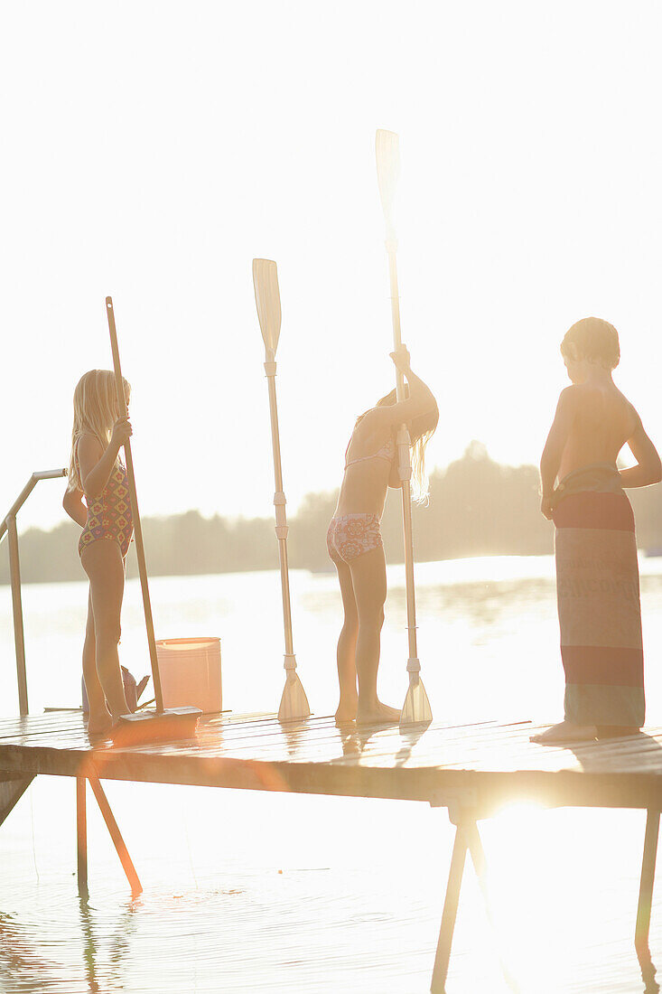 Children with paddles standing on a jetty at Lake Woerthsee, Bavaria, Germany, MR